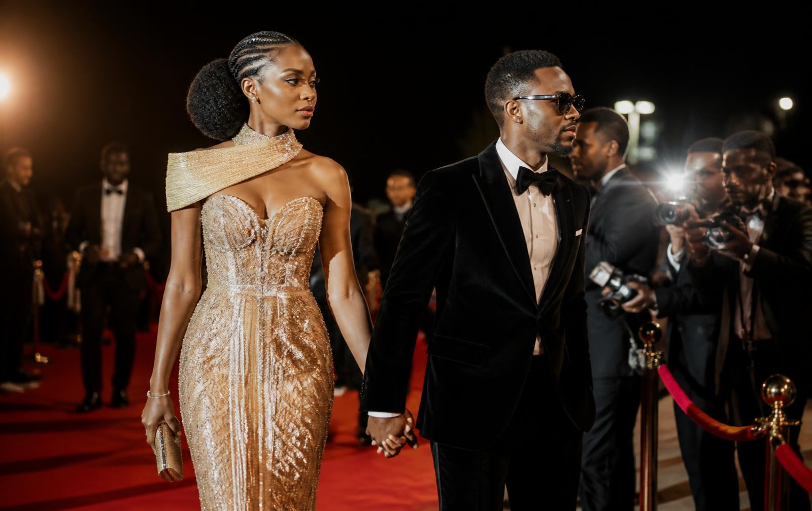 Guests in couture arriving on the red carpet amid camera flashes